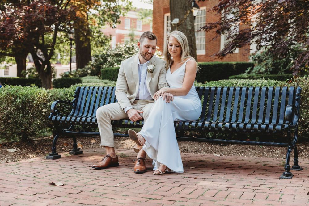 Wedding photo of couple sitting on a bench in downtown Annapolis. Annapolis wedding photographer