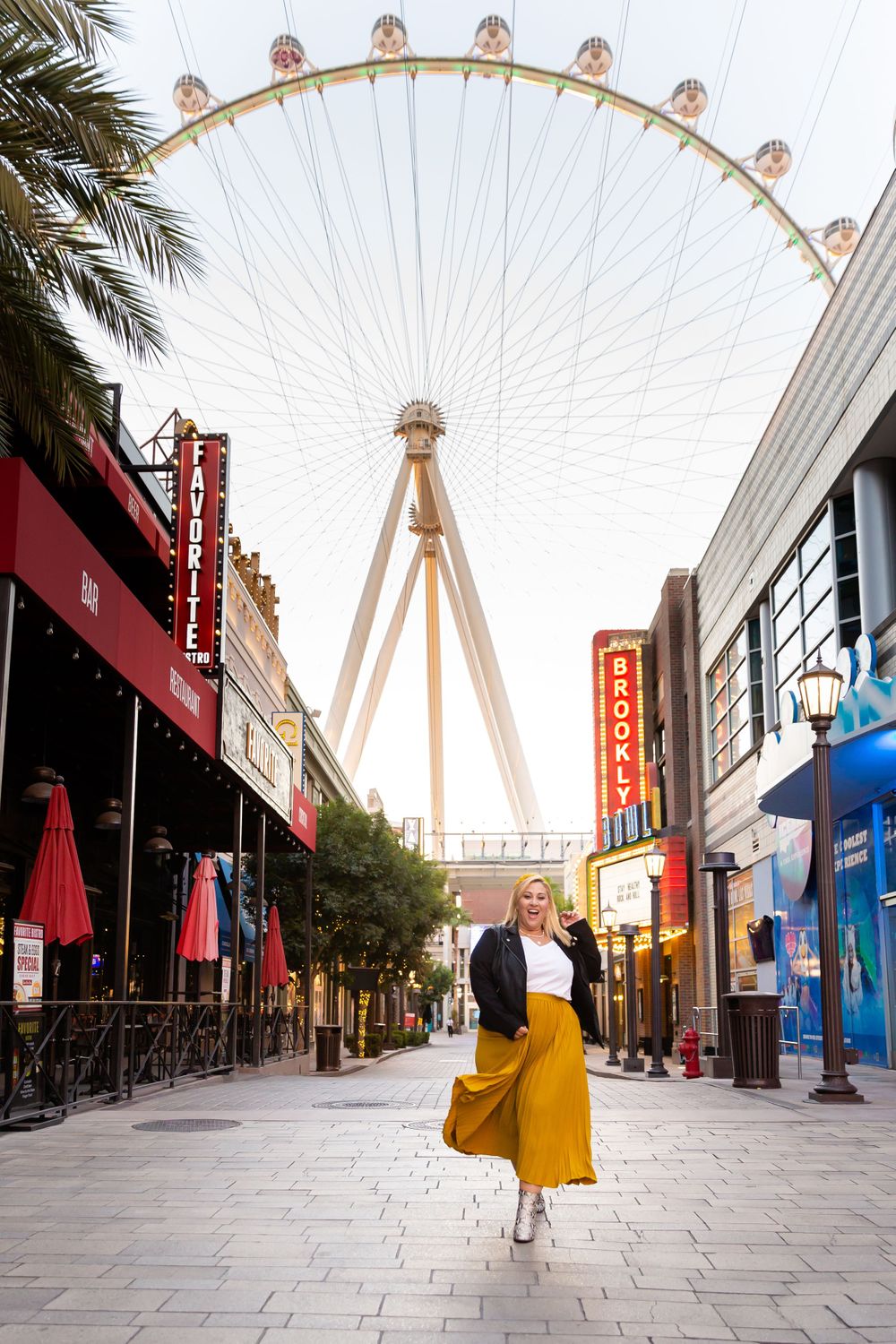 Stylish yellow skirt movement captured on the LINQ promenade with the High Roller wheel in background.