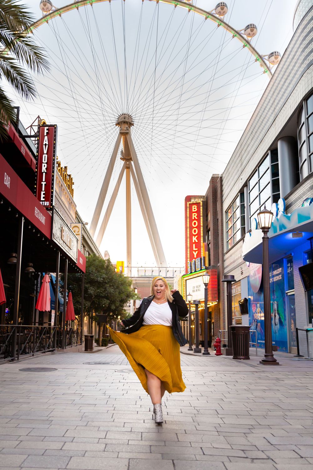 Dancing against the backdrop of the High Roller Ferris wheel with a flowing mustard yellow skirt.