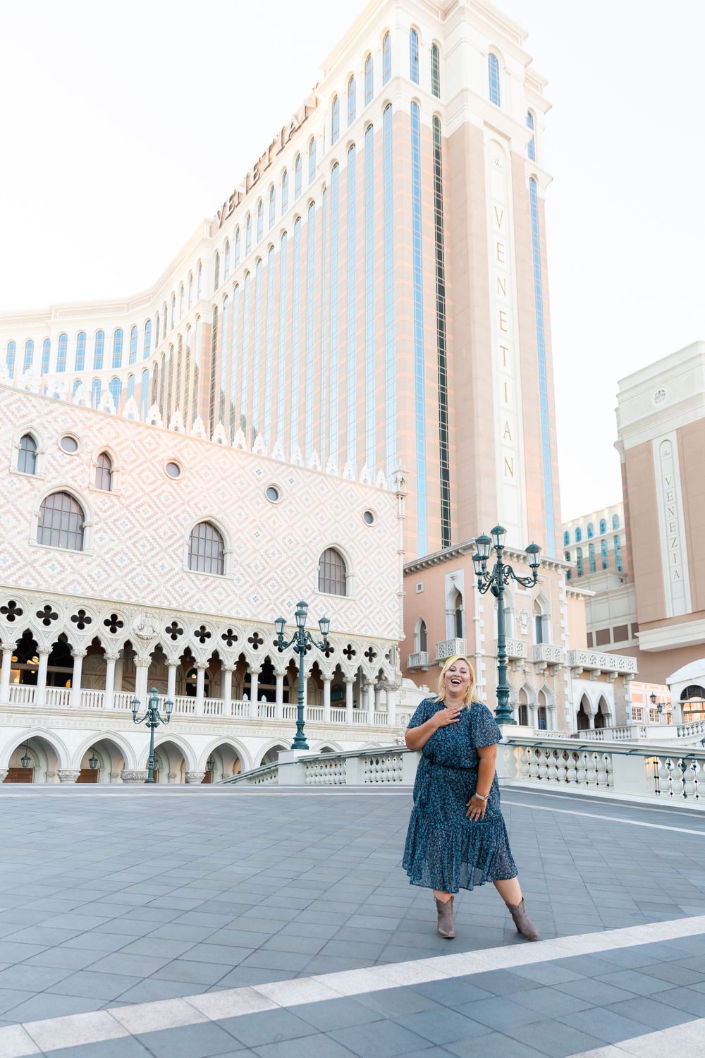 A joyful pose captured in front of The Venetian Las Vegas's grand facade with decorative columns and arches.