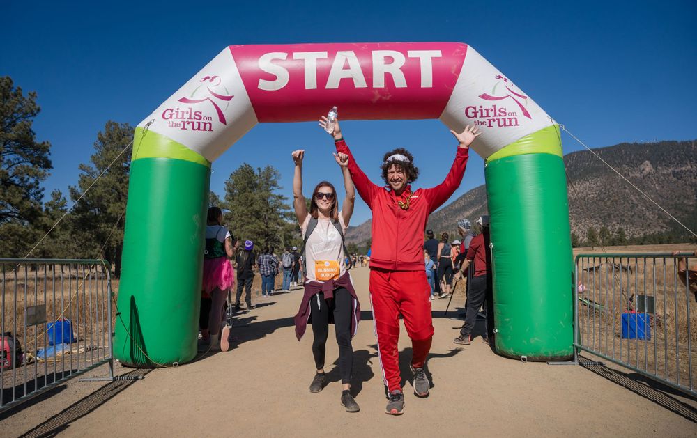 Man wearing retro running outfit crossing the finish line.