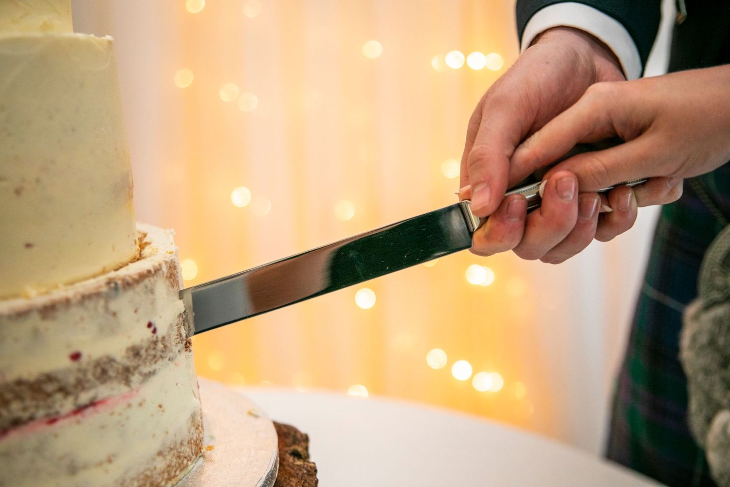 Close-up shots of hands cutting and serving wedding cake at reception.