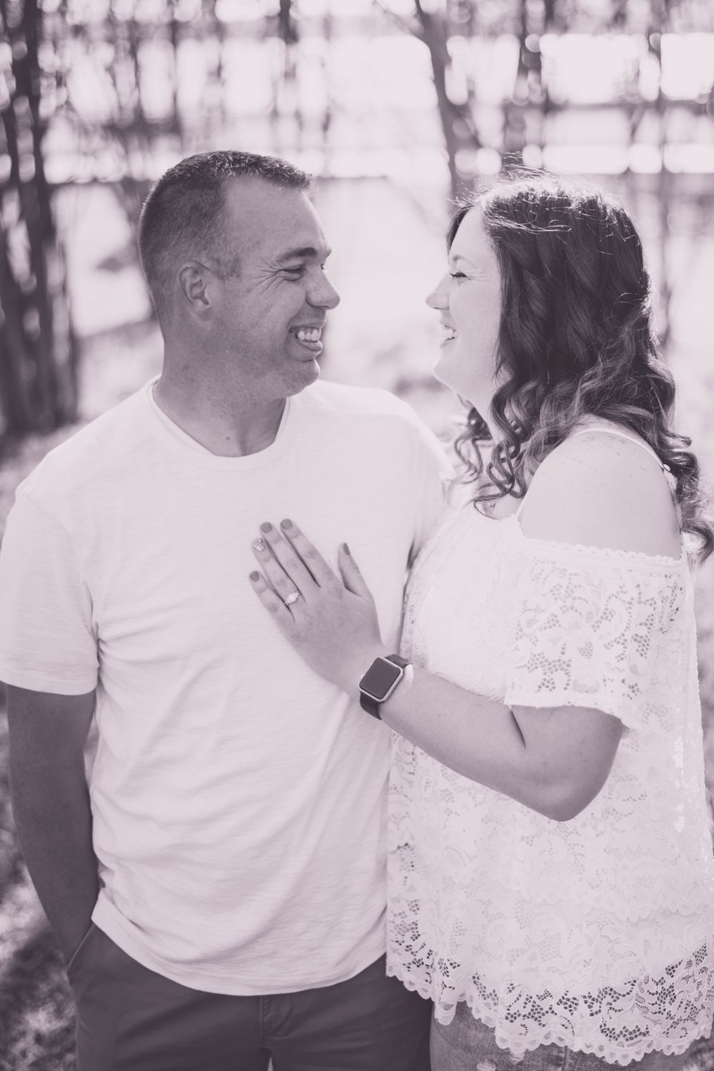 A couple sharing a tender moment outdoors in black and white photography.