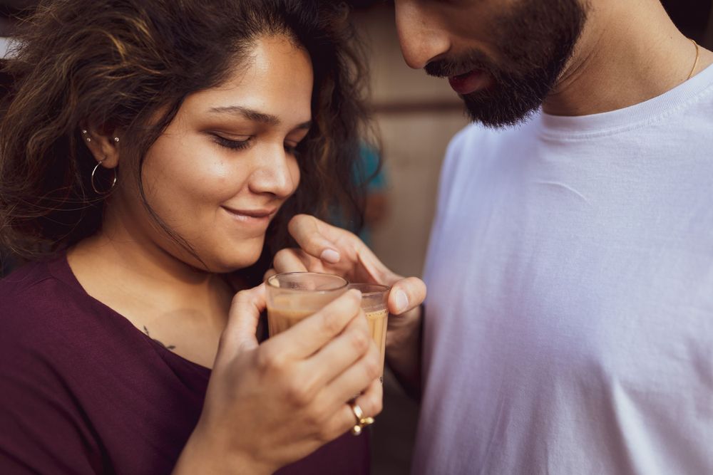 A couple holds hands intimately while sharing a tender moment together.