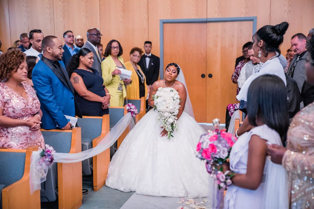 Wedding guests stand during emotional ceremony moment in modern chapel venue.