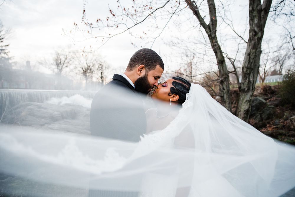 wedding veil bride and groom kiss