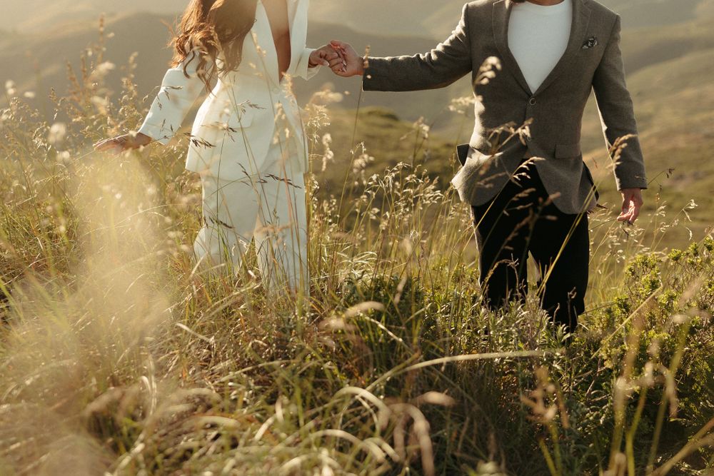 Close-up shot of formal attire and tall grass during a sunset photoshoot in the mountains.