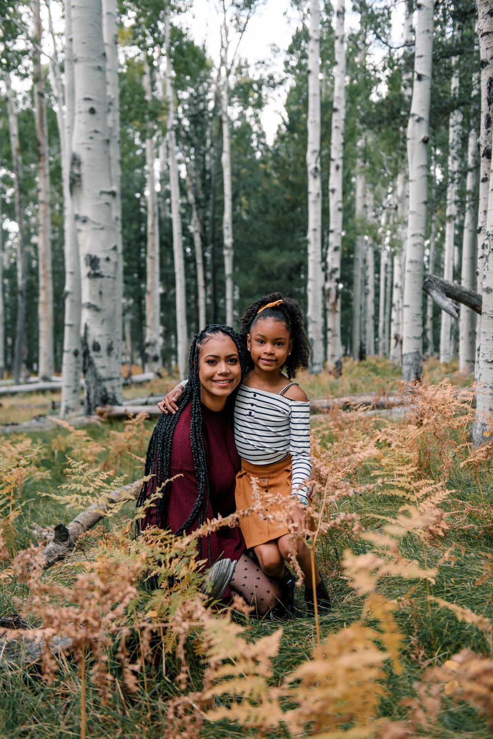 People sharing joyful moments among white birch trees and golden ferns.