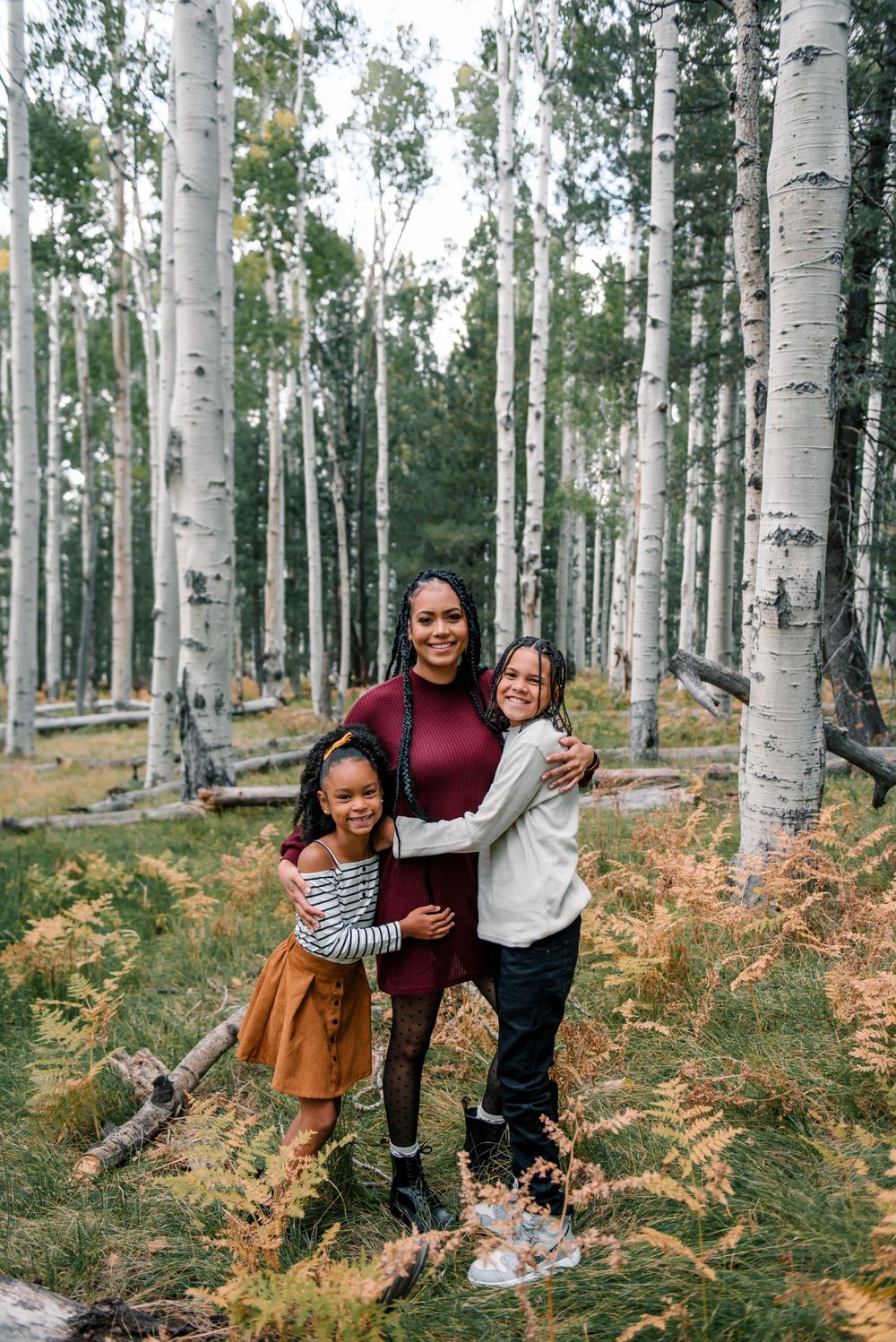 Family enjoying nature together in a scenic aspen grove with autumn colors.