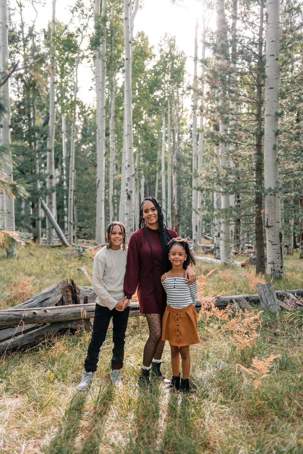 Casual family portrait in aspen grove with burgundy and earth-toned clothing choices.