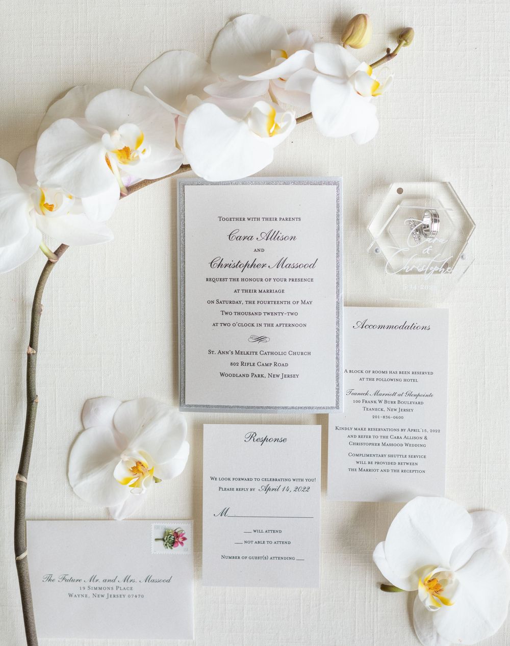 Wedding invitation suite with white orchids and ring box featuring elegant gray and white stationery.