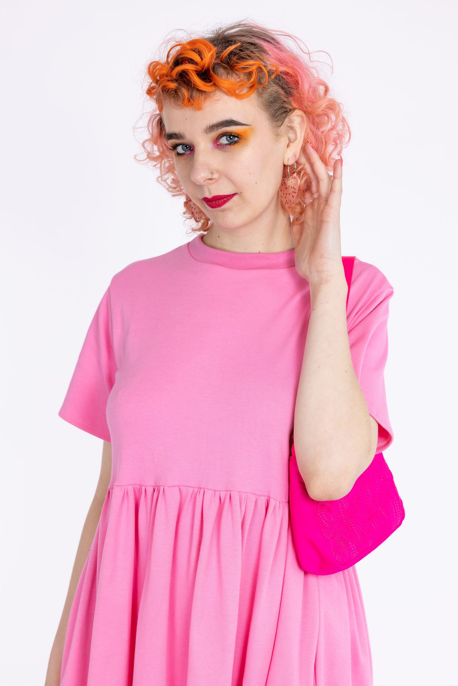 orange haired femme model wearing small business' Tallulah's Threads pink smock dress in a photography studio in Hove