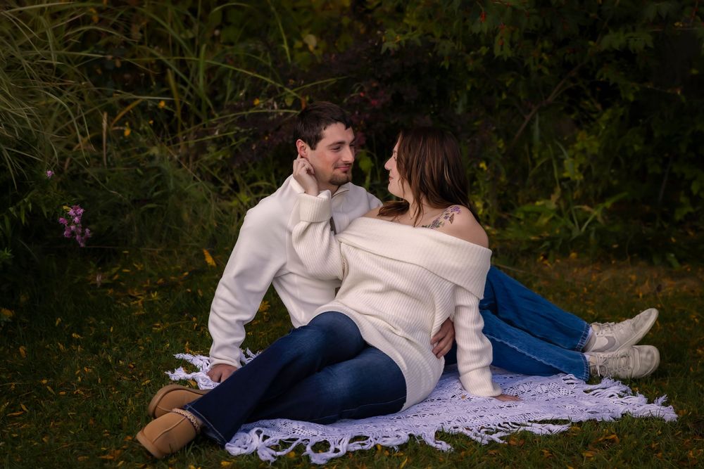 young couple sitting on the grass looking at each other