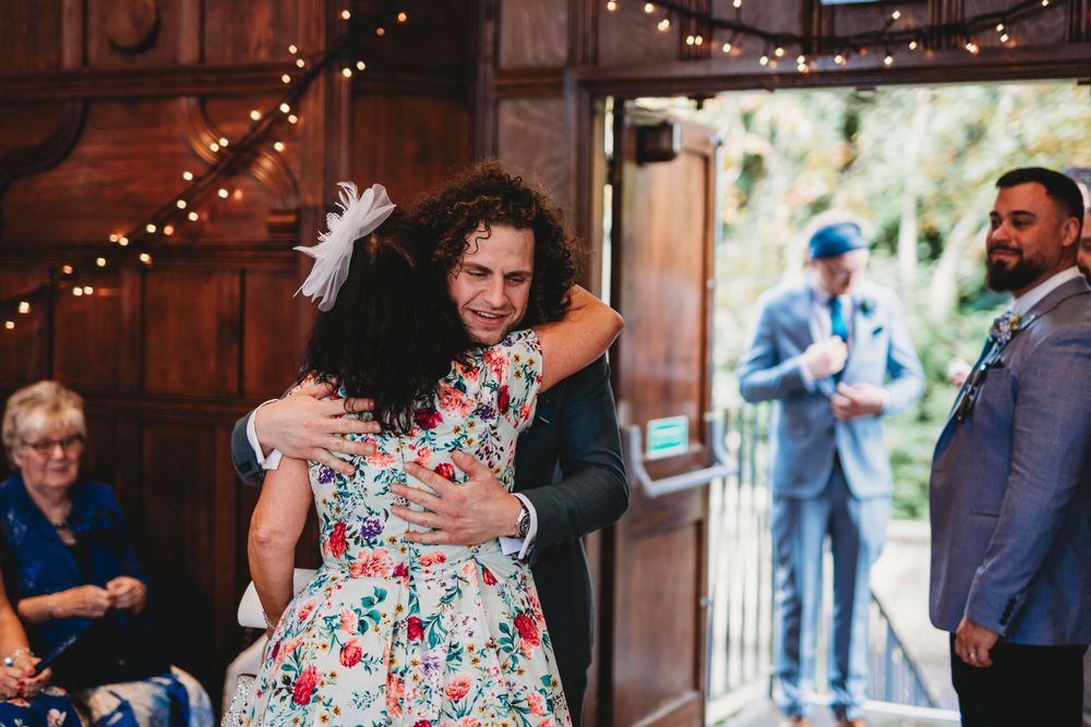 Wedding celebration in a rustic venue with wooden walls and string lights creating warm ambiance.