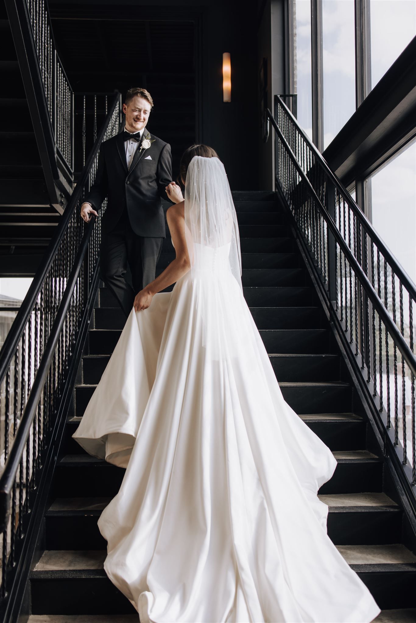 A dramatic staircase photo showcasing an elegant white wedding dress train.