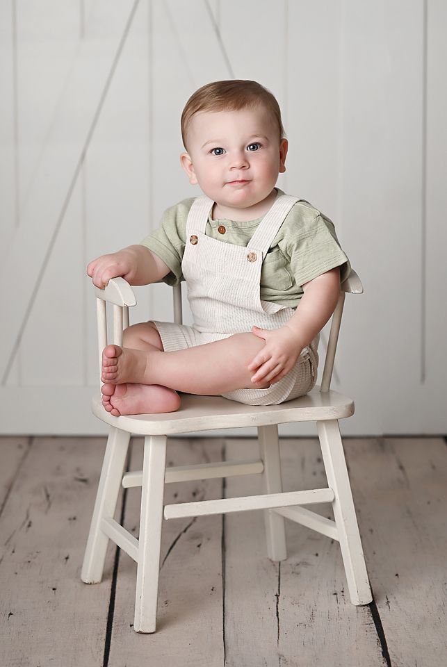 One year old posed in a white chair