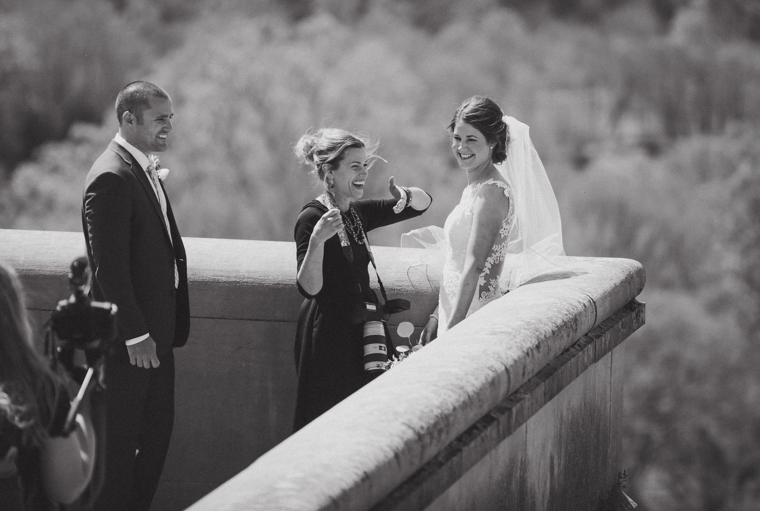 Black and white photo of wedding ceremony on stone overlook with mountain views.