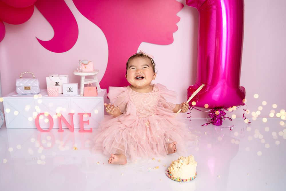 Pink themed birthday photoshoot with number one balloon and sparkly decorations.