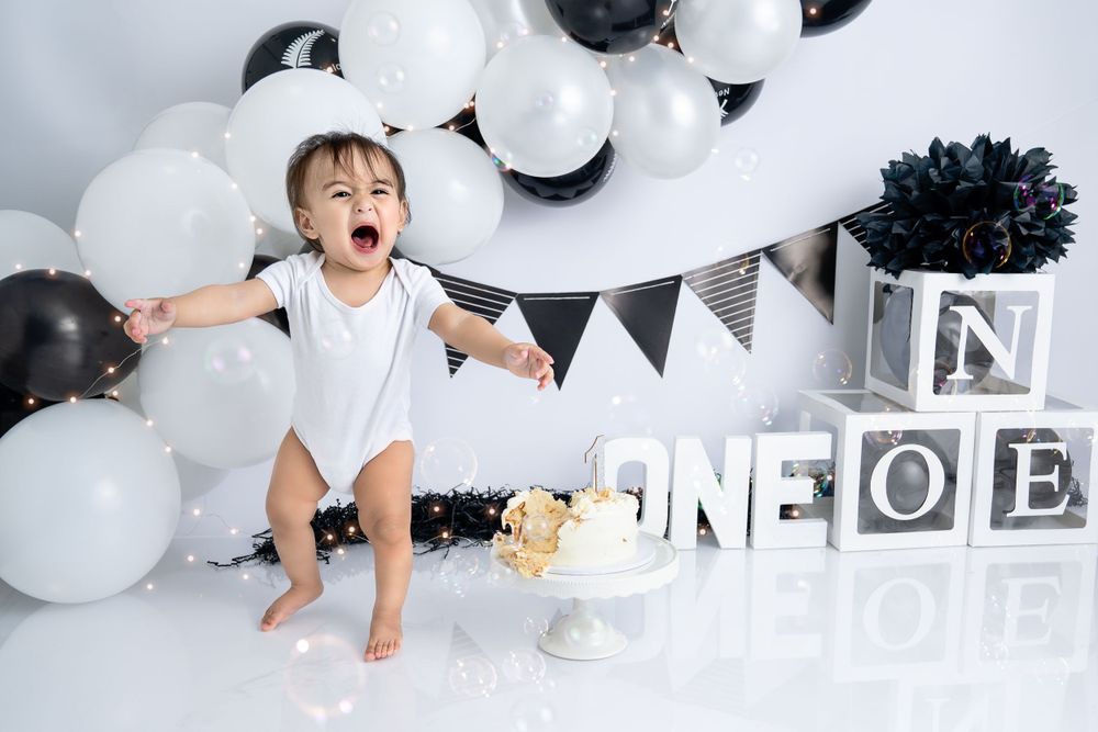 Minimalist black and white birthday setup with letter blocks and balloon decorations.