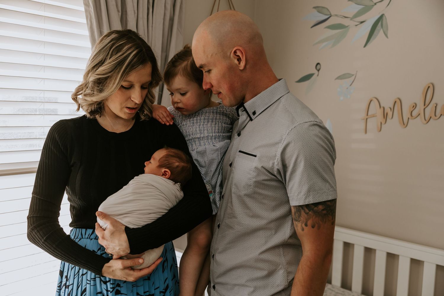 Intimate indoor family lifestyle photos showing tender moments in a nursery setting.