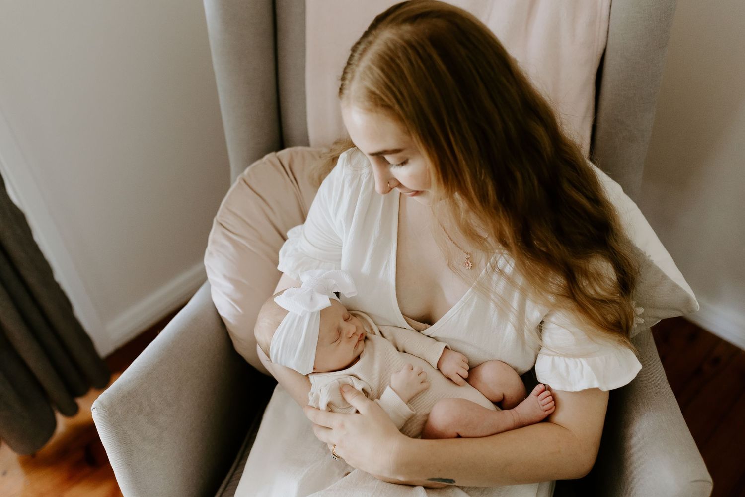 Intimate indoor family photoshoot featuring parents cradling their newborn.
