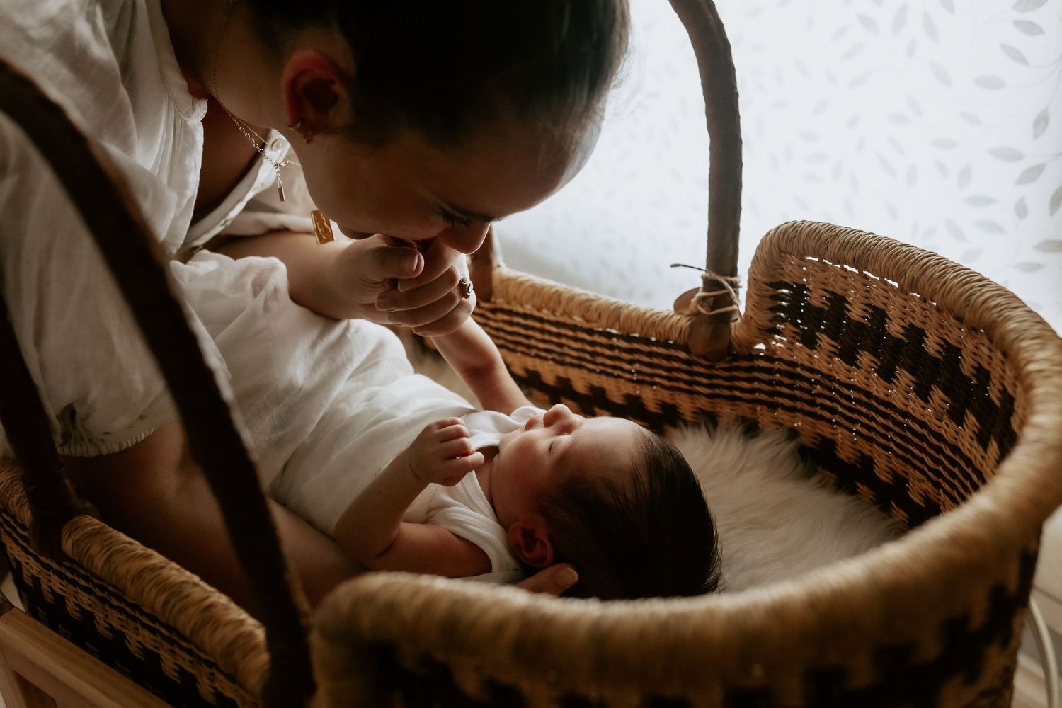 Artistic overhead shot of baby lying in woven basket during portrait session.
