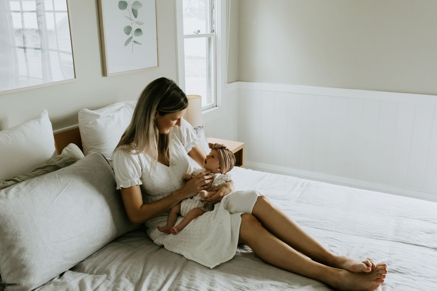 Casual indoor photoshoot featuring botanical wall art and white furniture.