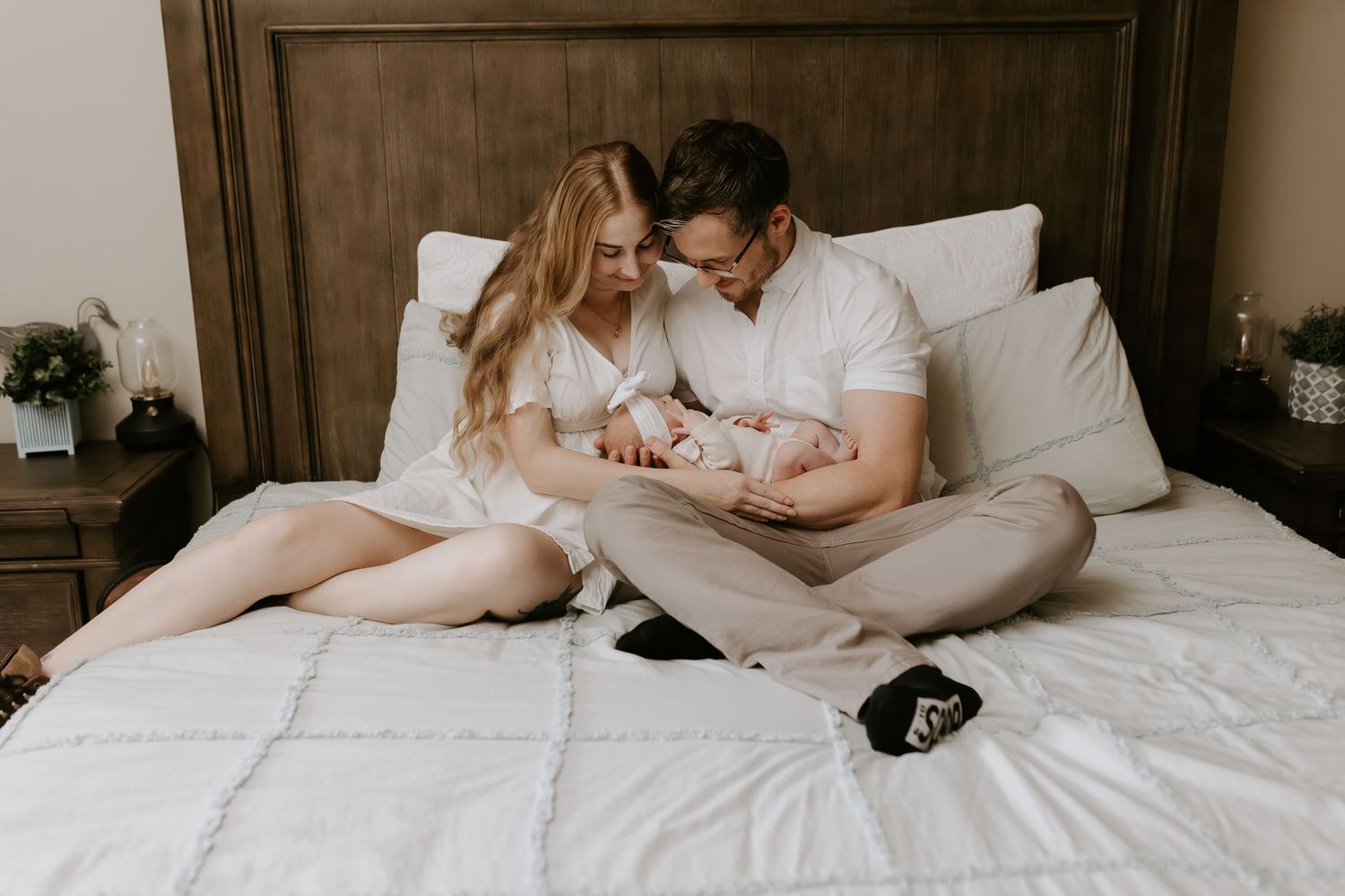 Intimate lifestyle photography of couple relaxing together on white bedding.