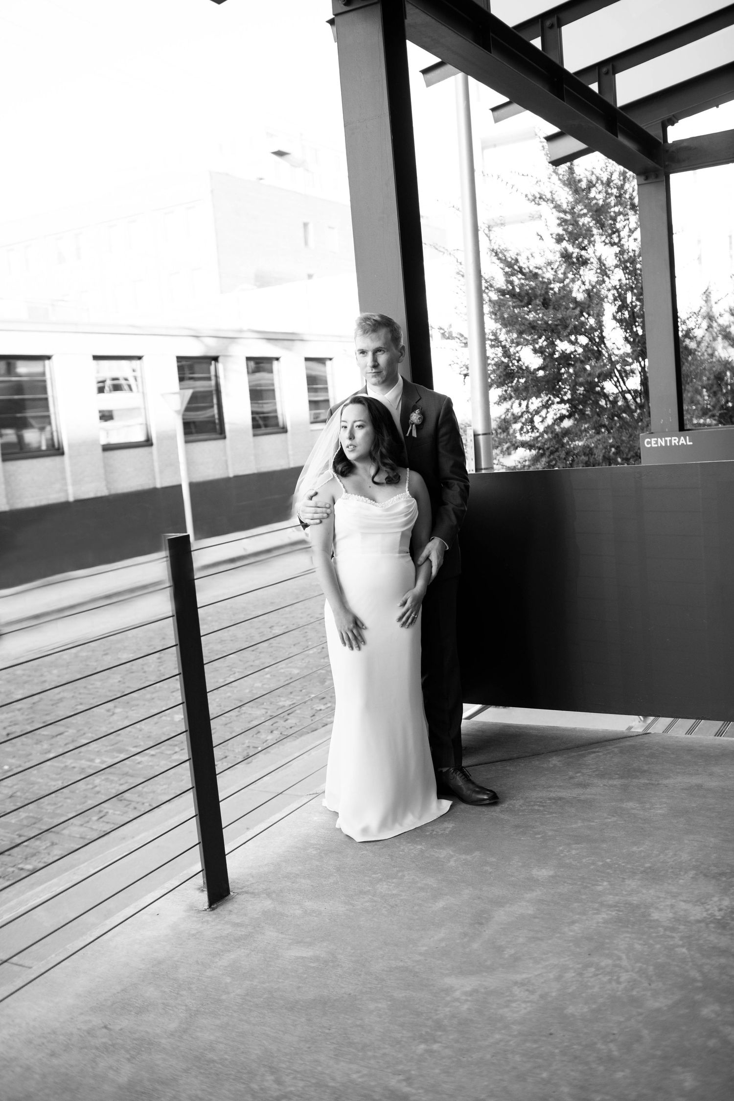 Black and white wedding portrait on an outdoor terrace with city views.