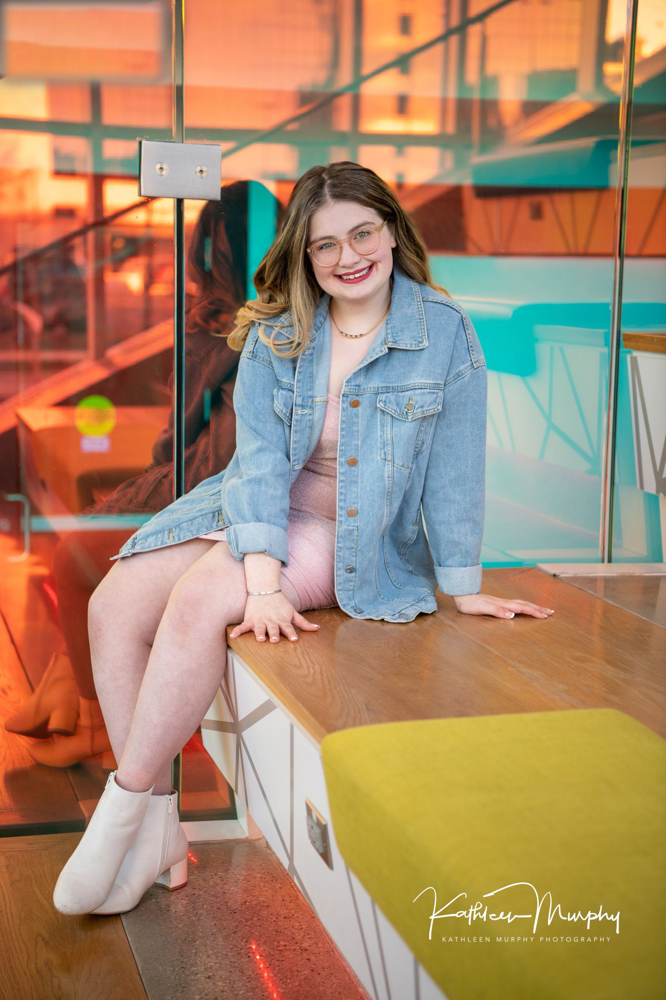 Portrait in casual denim styling against colorful modern geometric backdrop.