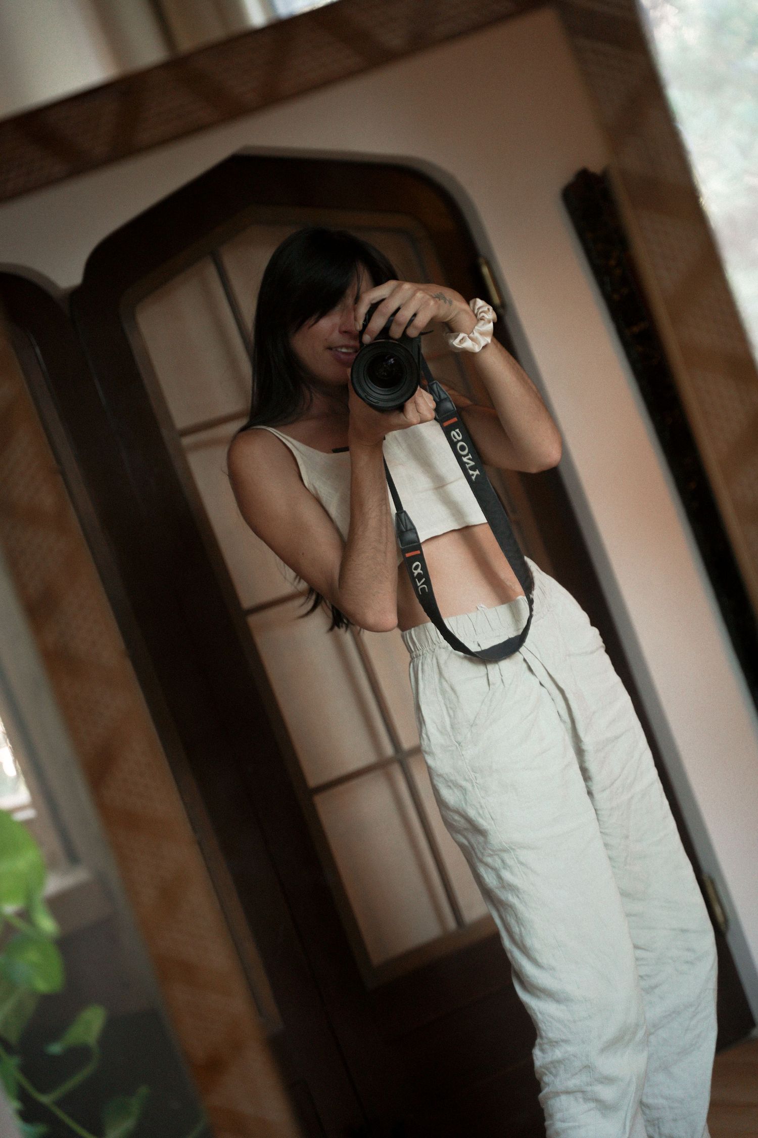 Mirror self-portrait of someone taking a photo while wearing white overalls.