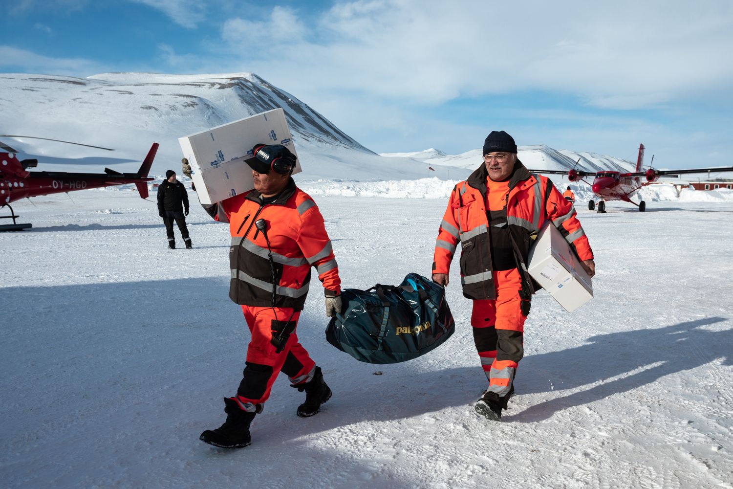 Split two men carry luggage to plane on Iceland runway