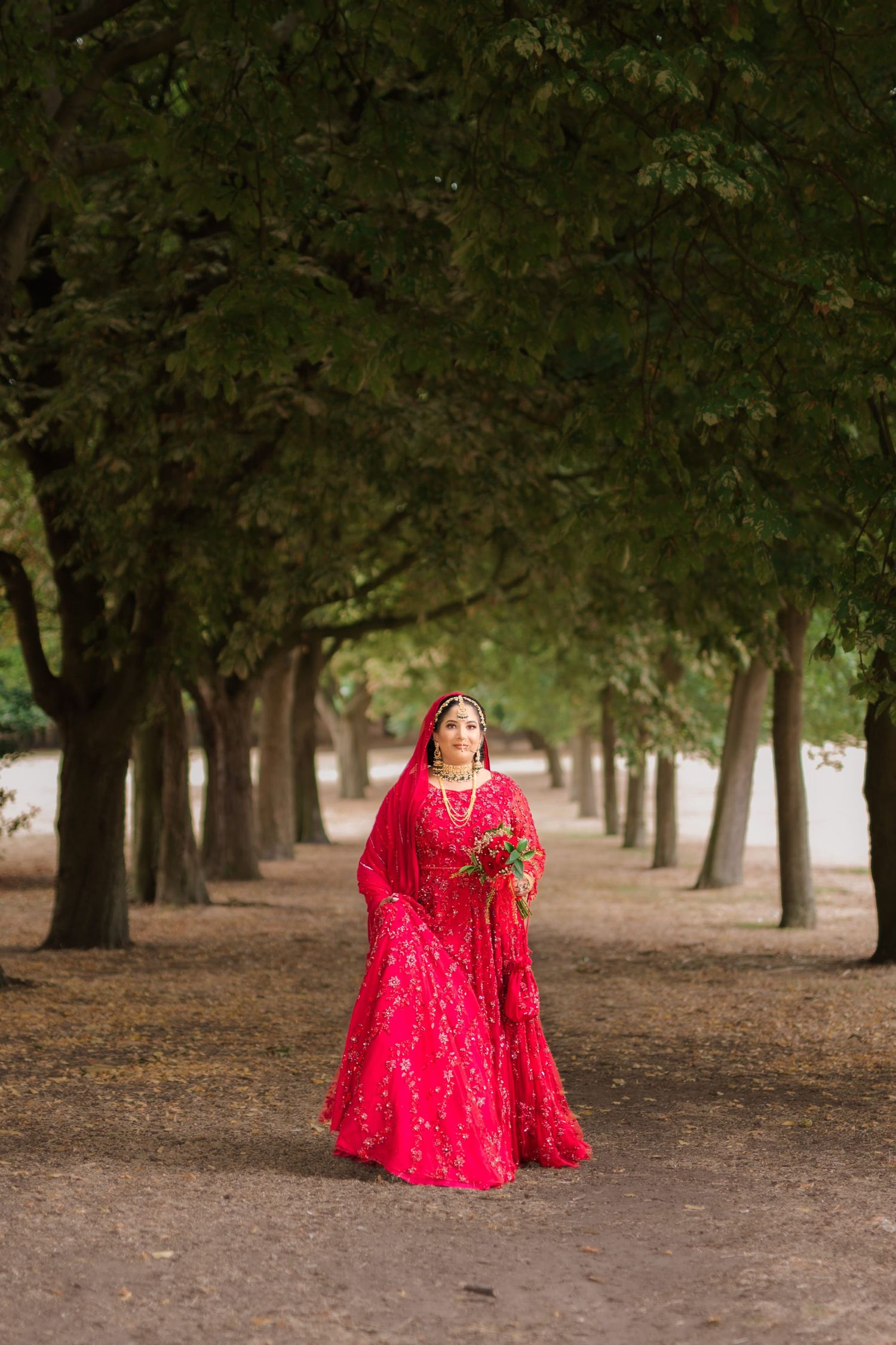 Joyful newly wed practising her bridal flower through in front of the photographers camera