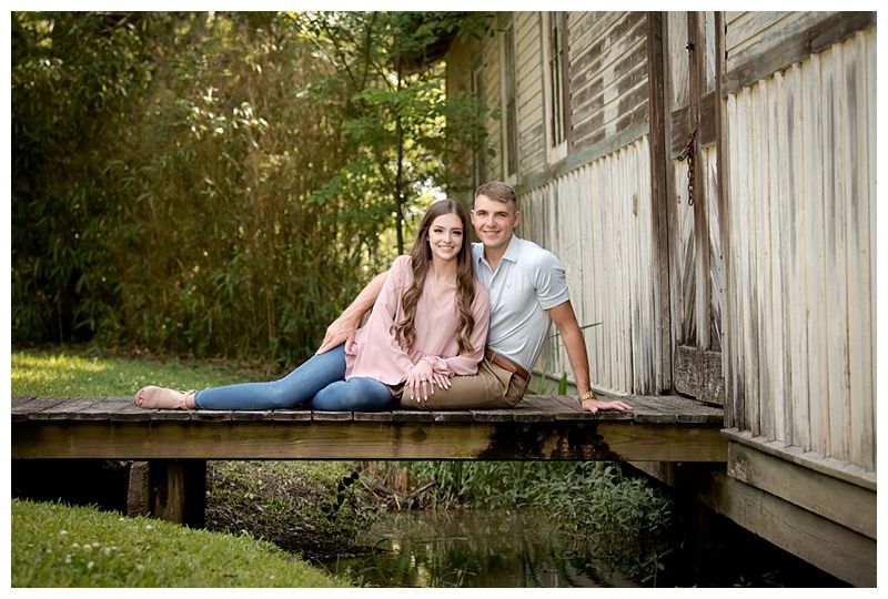 Engagement photos on rustic wooden porch with natural lighting.