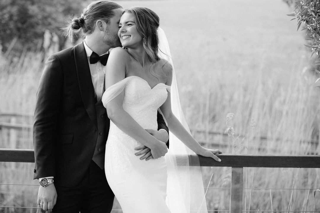 Black and white wedding photos showing romantic moments between couples in an outdoor setting.