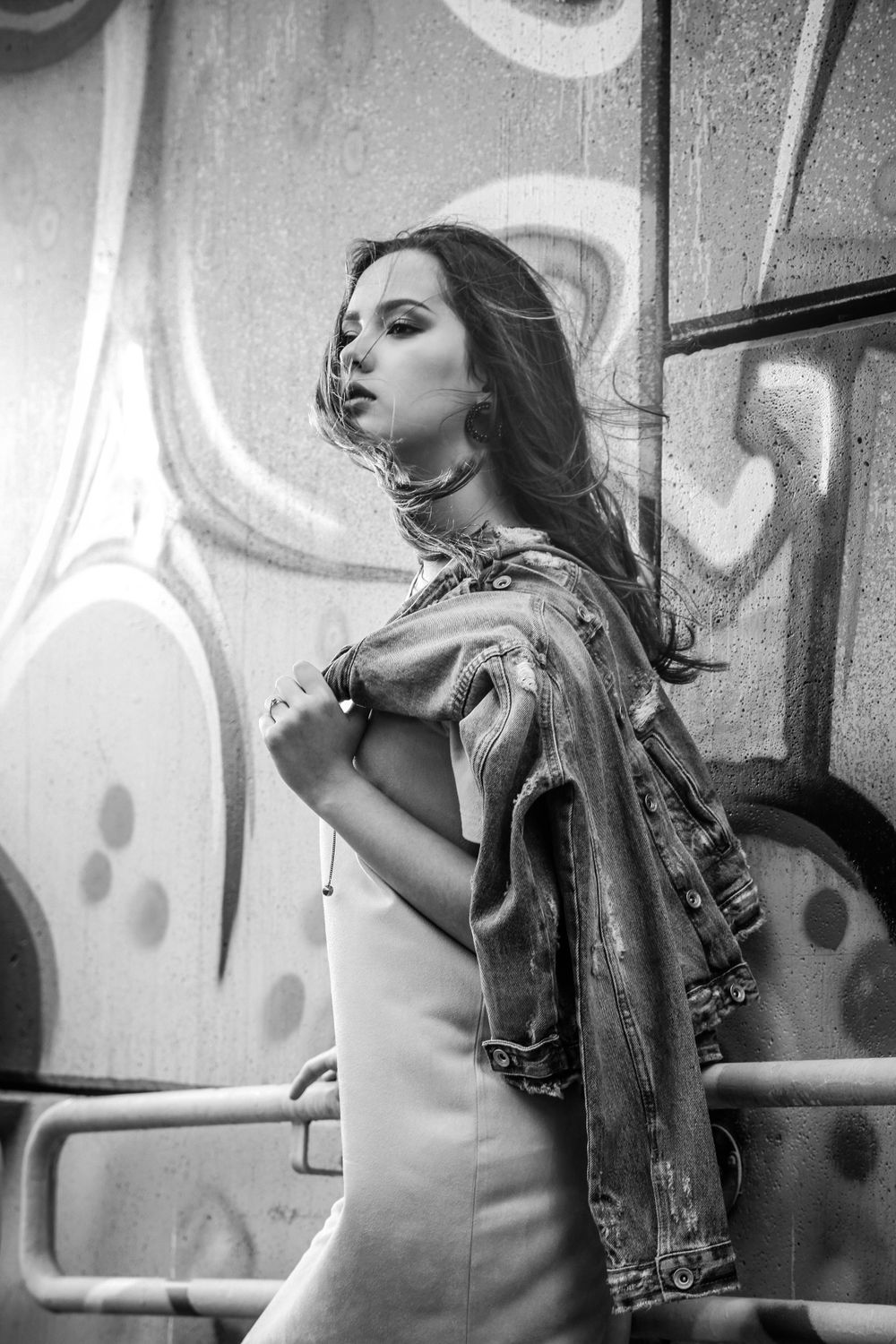 Edgy urban photoshoot with dramatic black and white poses against graffiti wall.