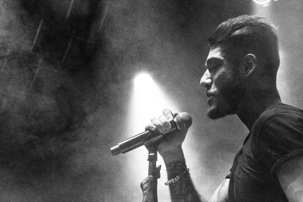 Black and white concert photography showing performers in atmospheric stage lighting.