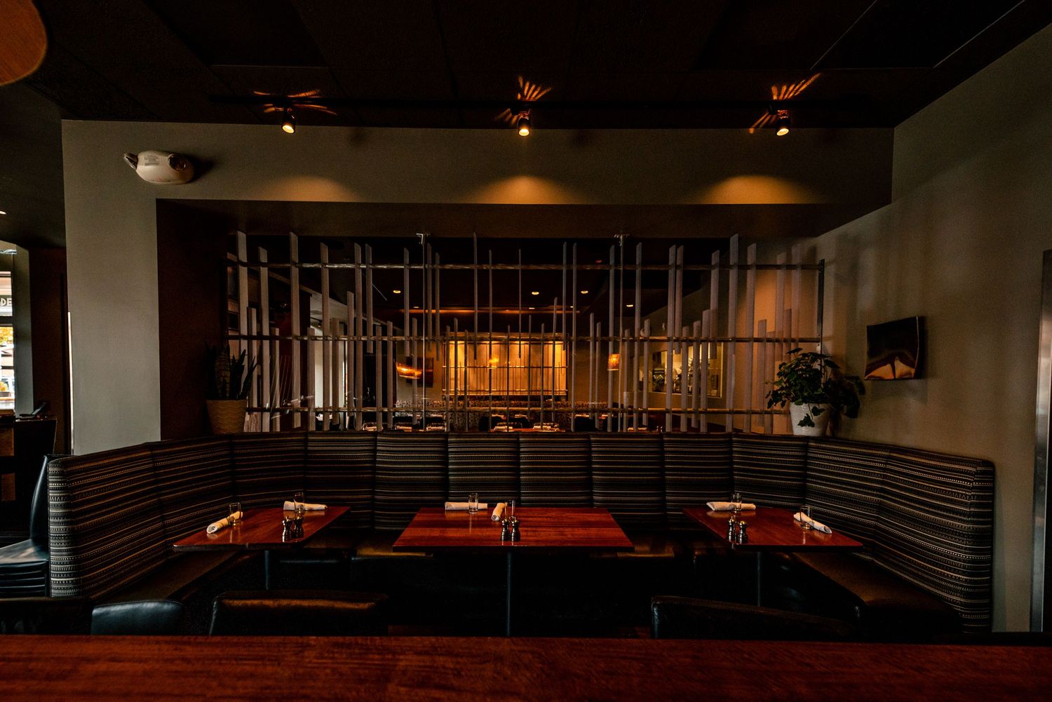 Modern restaurant interior with red booth seating and industrial metal decor.