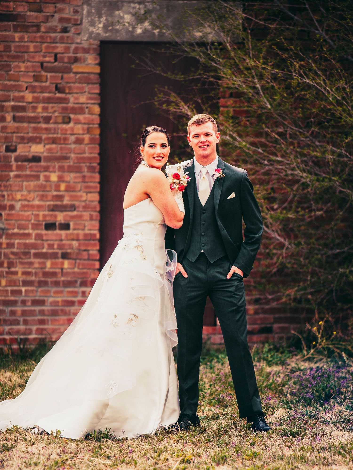 Couple posing for Prom pictures in front of brick wall