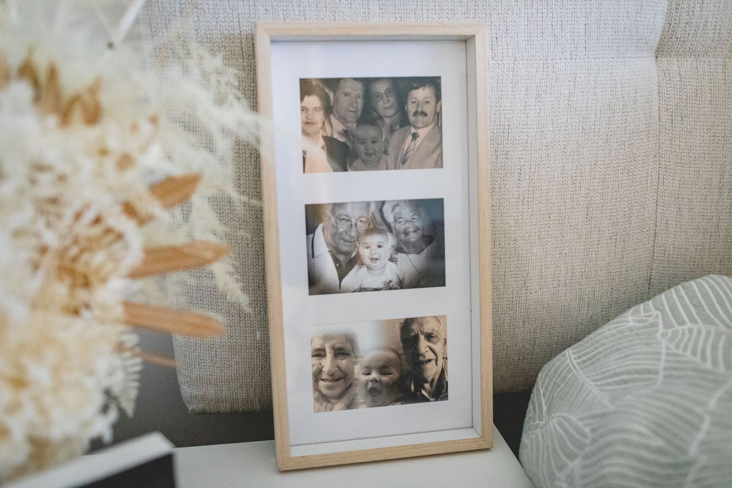 A framed collage of family photographs displayed on a textured surface.