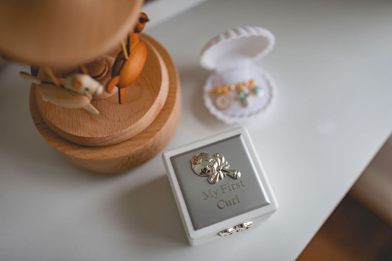 Small decorative boxes and carousel arranged on white surface.