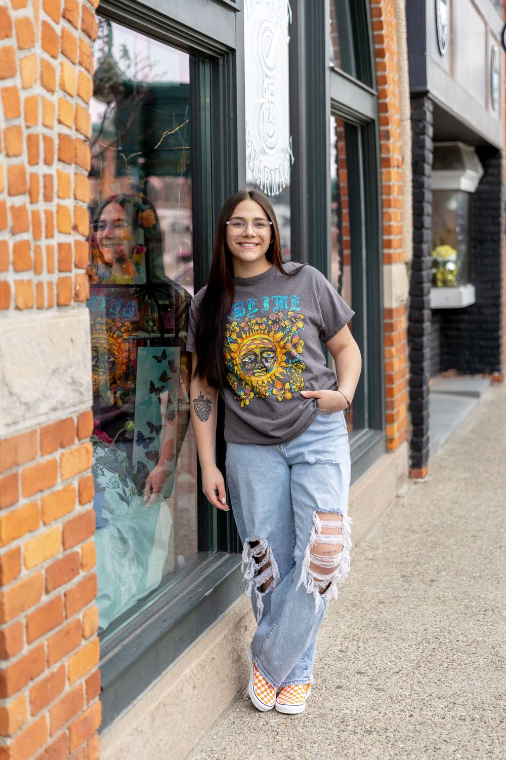 teenage girl in a nirvana shirt and jeans leaning on a building in Rochester michigan