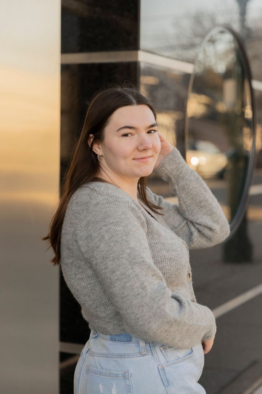 teenage girl posing in front of a storefront in downtown Rochester Michigan in the winter
