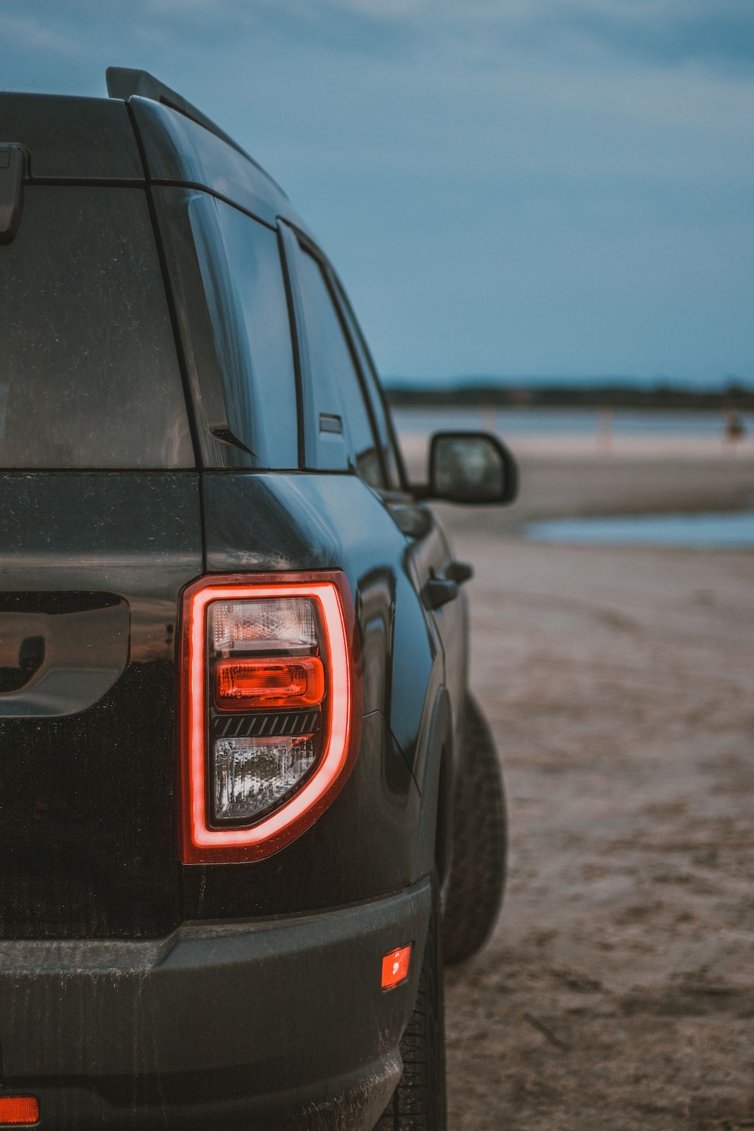 Rear quarter view of a Ford Bronco Sport showing distinctive C-shaped LED tail light.