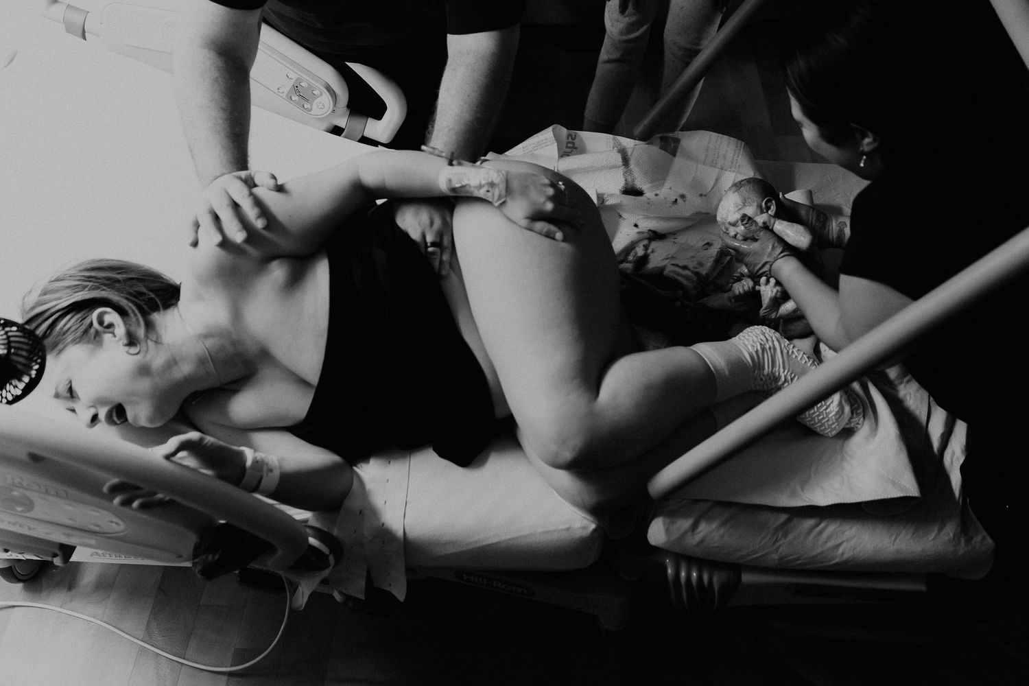 woman laying down giving birth. unmedicated natural birth in dallas Texas.