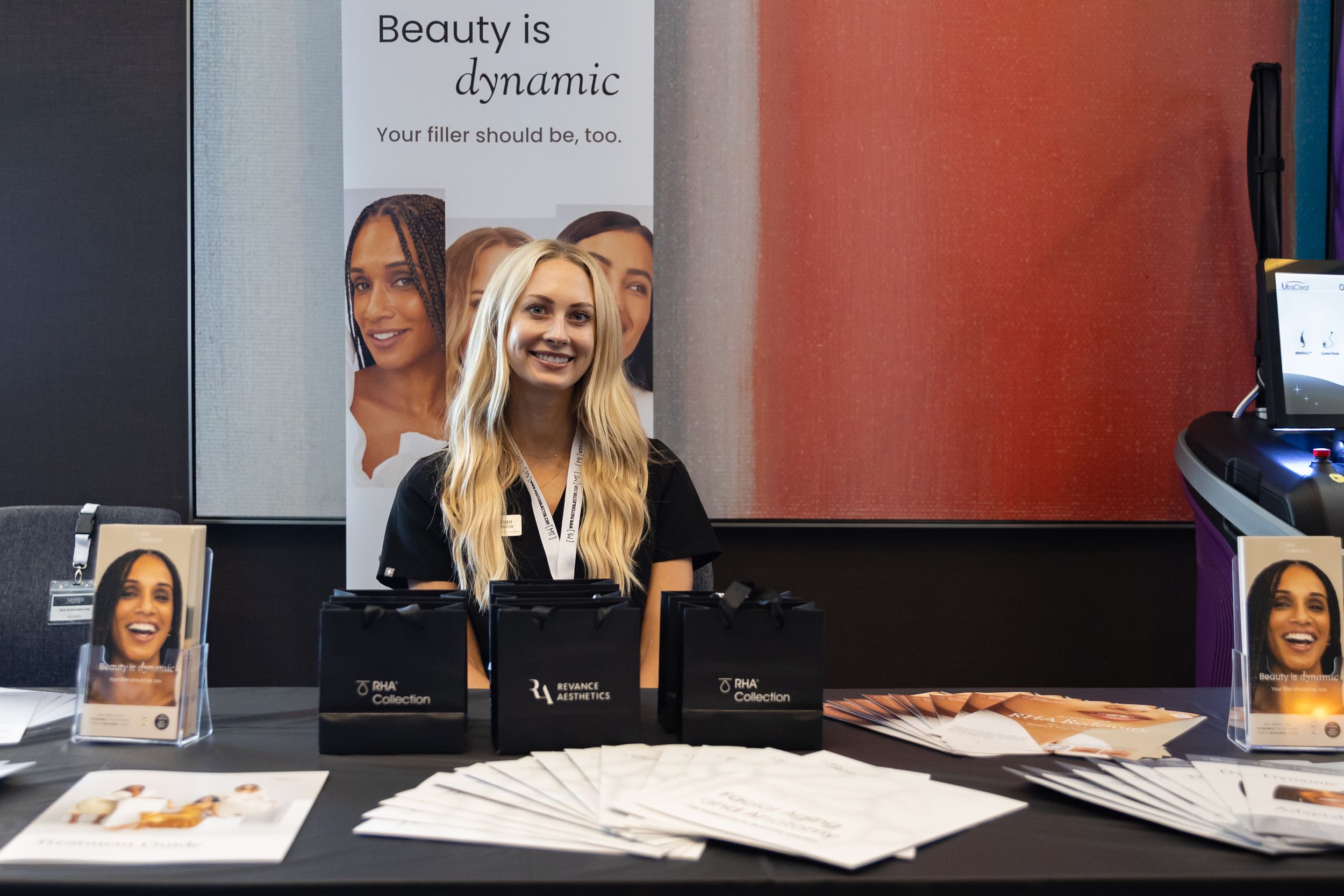 Marketing display with beauty products and promotional materials featuring dynamic beauty theme signage and brochures on table.