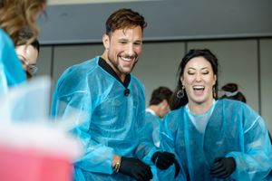 Team members in medical protective gear share joyful laughter during training.