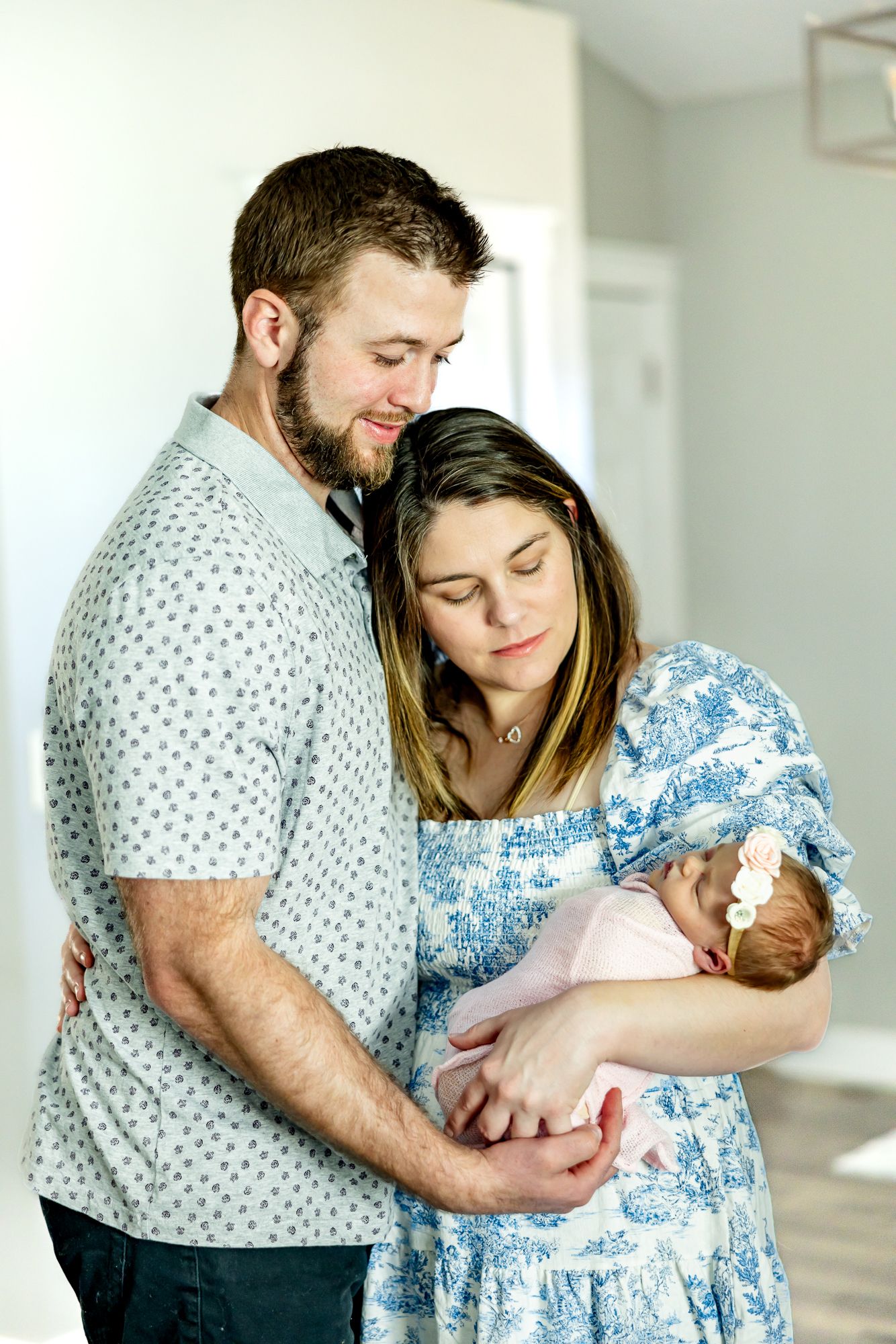 Parents stand in their house holding and gazing at their new baby girl during lifestyle newborn photos in Colorado Sprin