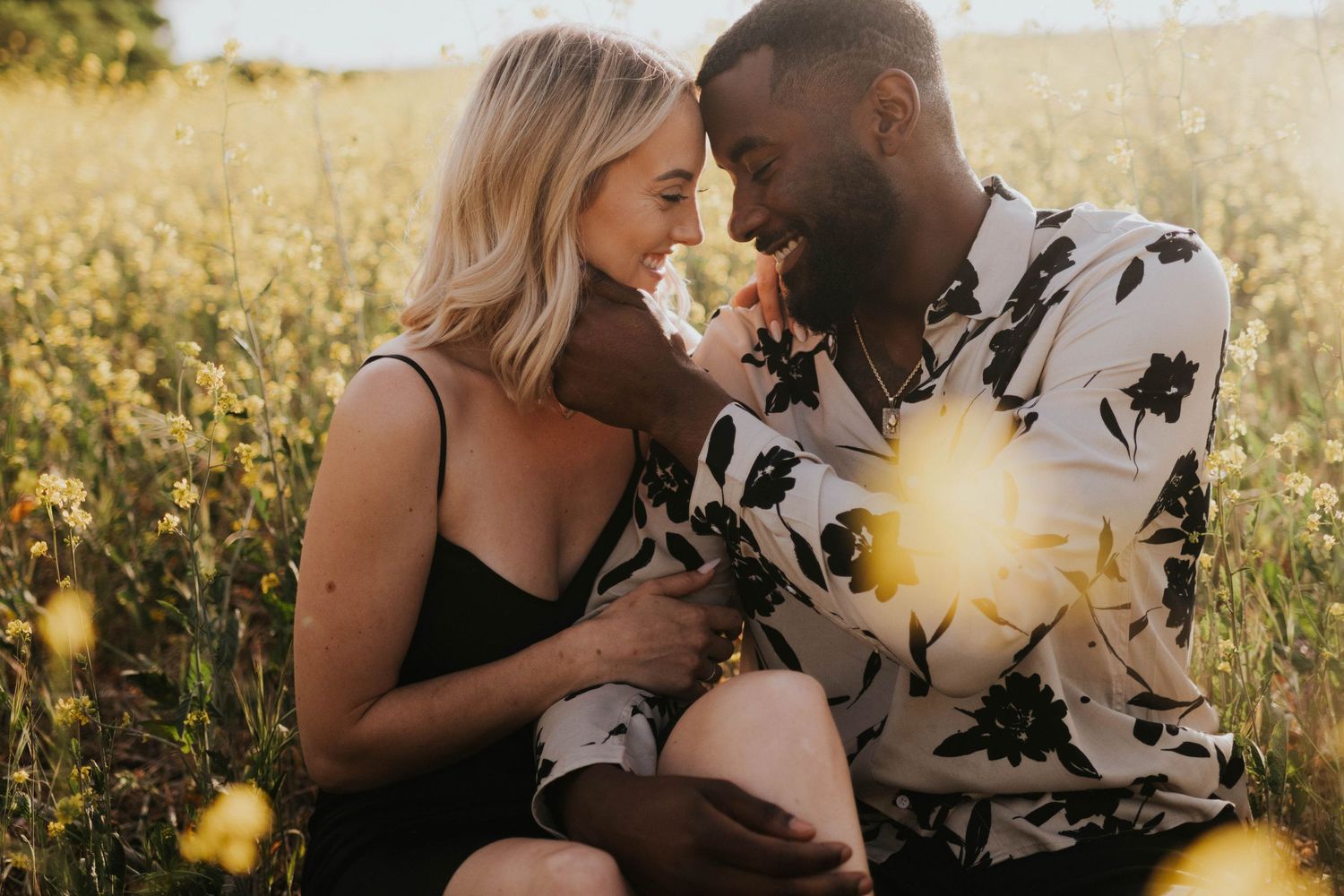 A couple embraces in a field of yellow wildflowers near Anaheim, CA with their destination wedding photographer.