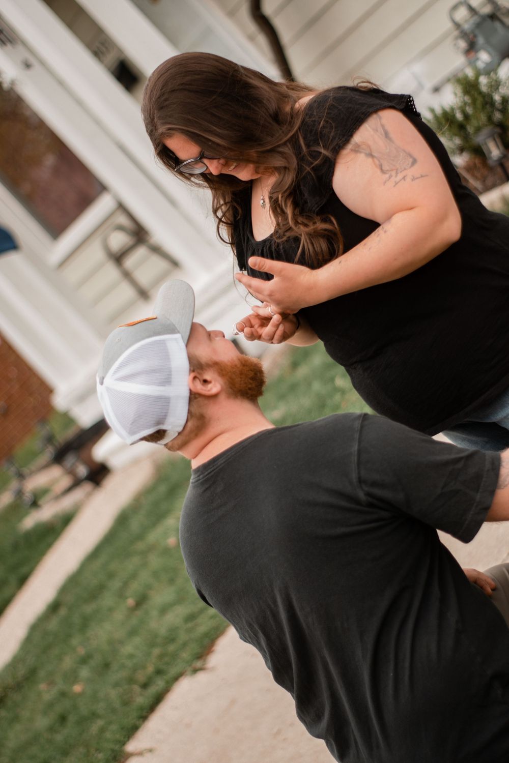 A tender embrace captured in front of a white building exterior.